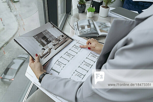 Interior designer examining blueprint at office