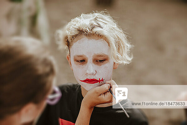Boy having face painting from artist