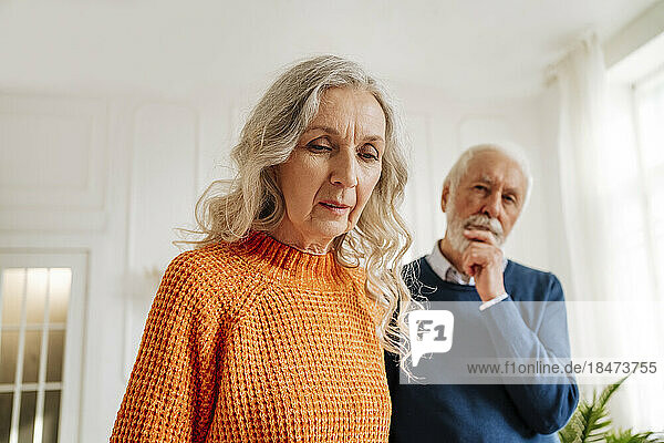 Senior woman with thoughtful man at home