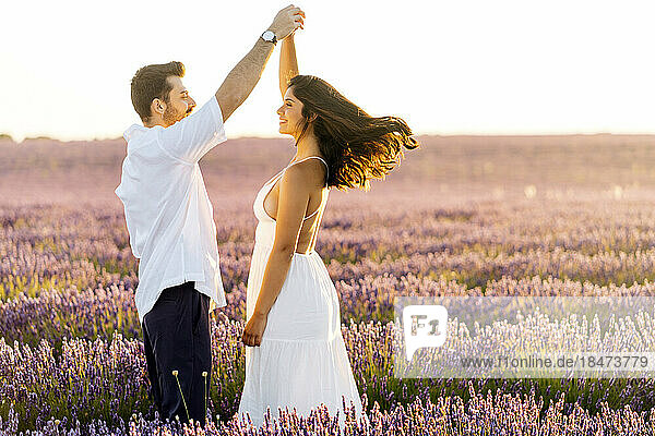 Glücklicher Mann tanzt mit Frau im Lavendelfeld
