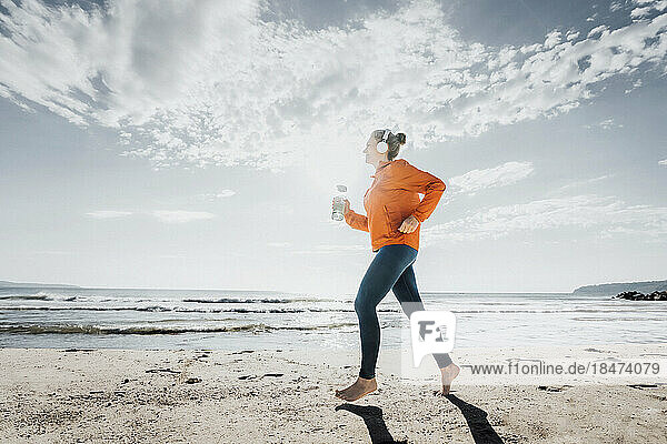 Frau joggt an einem sonnigen Tag am Strand