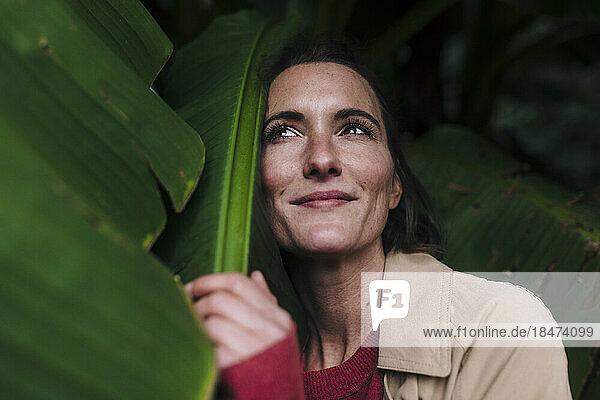 Thoughtful woman with banana leaf