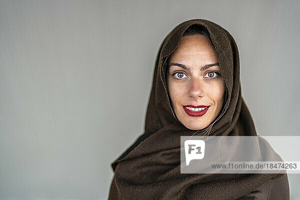 Glückliche Frau mit Hijab vor grauem Hintergrund
