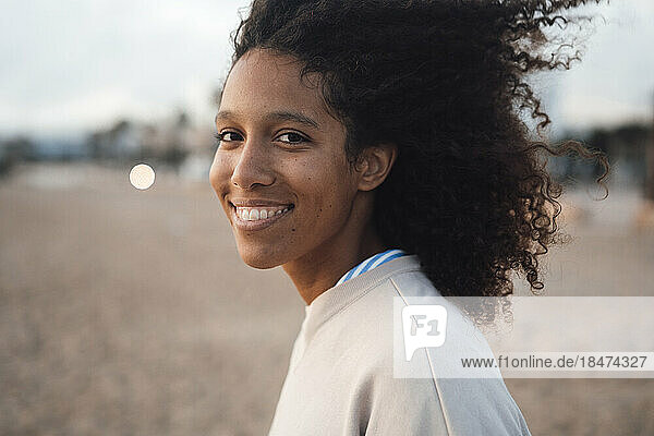 Happy woman with Afro hairstyle at beach