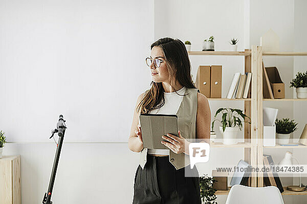 Thoughtful businesswoman with tablet PC in office