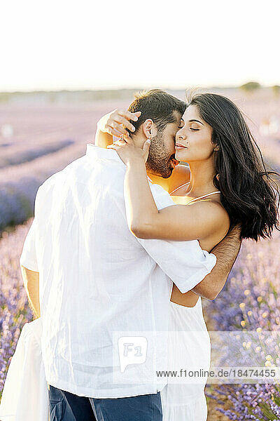 Man embracing young woman on lavender field