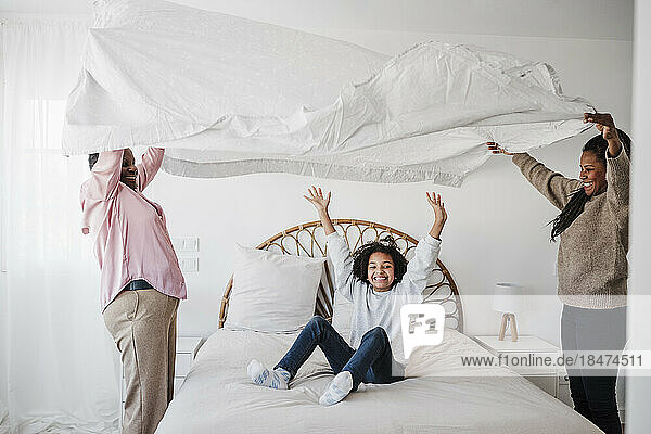 Happy family enjoying together in bedroom at home