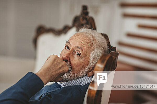 Senior man sitting on chair at home