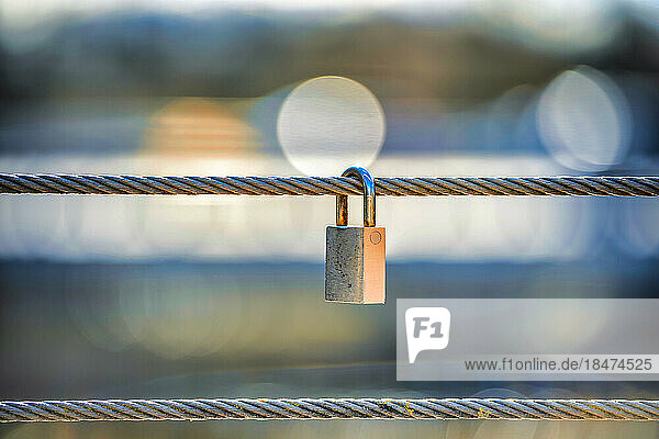 Padlock hanging on steel cable