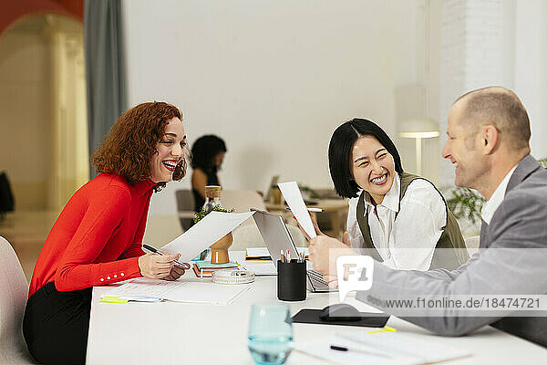 Happy business colleagues having discussion in office