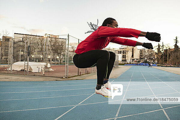 Athlete doing jumping exercise on sports track