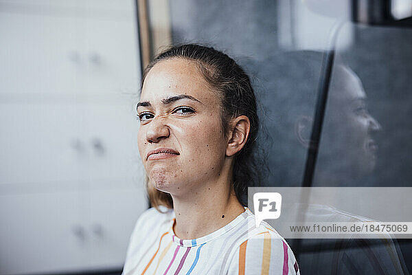 Businesswoman making face sitting in office