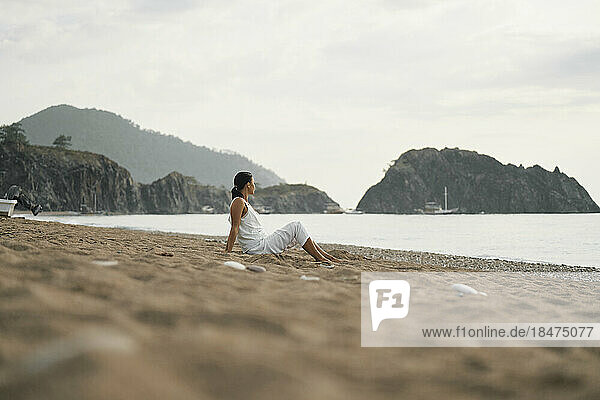Woman sitting on sand at beach