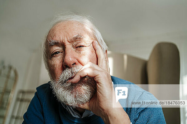 Thoughtful senior man with gray hair sitting at home