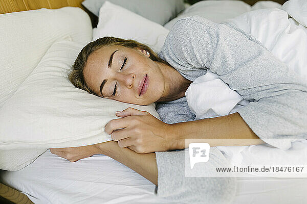 Woman sleeping in bed at home