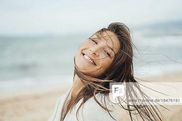 Glückliche Frau mit langen Haaren  die am Strand genießt