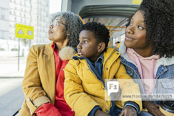 Mehrgenerationenfamilie schaut durch das Fenster der Straßenbahn