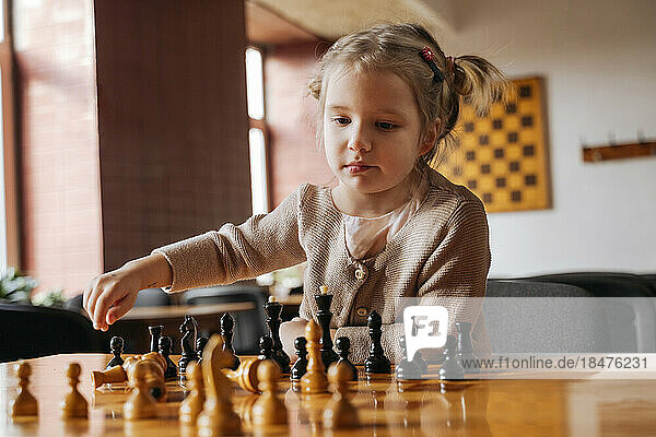 Cute girl playing chess at club house