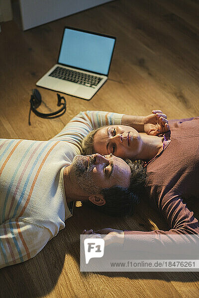Freelancer lying down on floor with husband at home