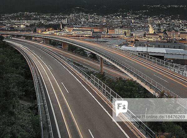 Österreich  leichte Fahrzeugspuren  die sich in der Abenddämmerung entlang der Hochstraße erstrecken