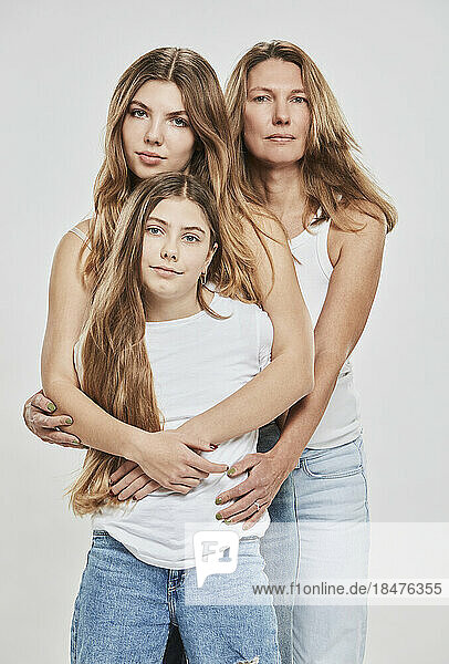 Mutter und Töchter zusammen vor weißem Hintergrund