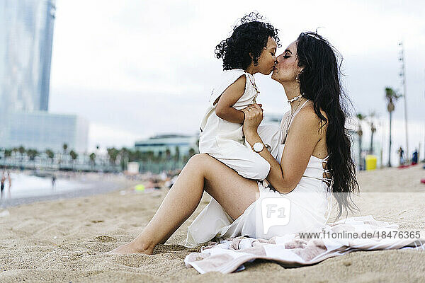 Boy kissing mother on mouth at beach