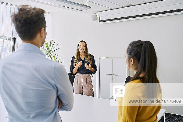 Manager gesturing in meeting with colleagues at workplace