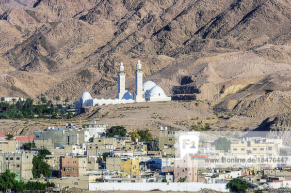 Sheikh Zayed Mosque and buildings in front of mountains on sunny day