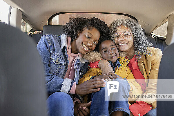Smiling multi-generation family sitting together in car