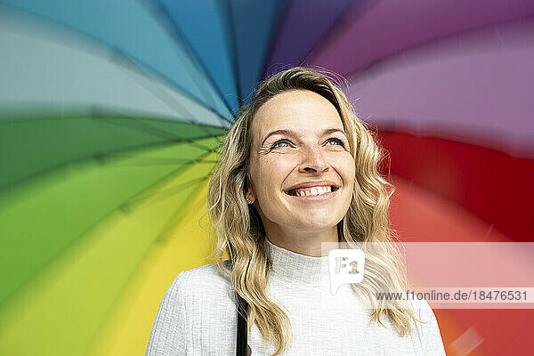 Blond happy woman with multi colored umbrella