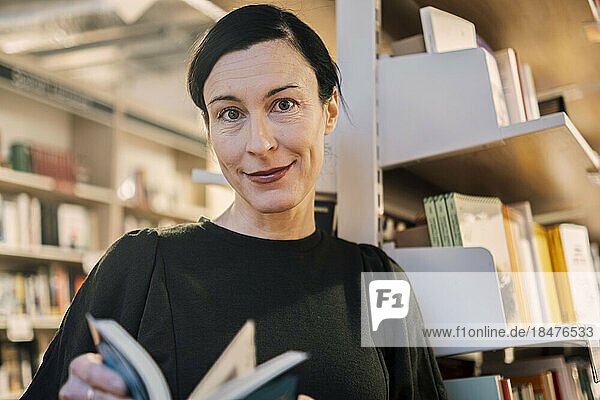 Woman with book in library
