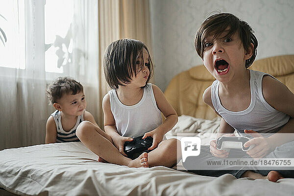 Happy brothers playing video games at home