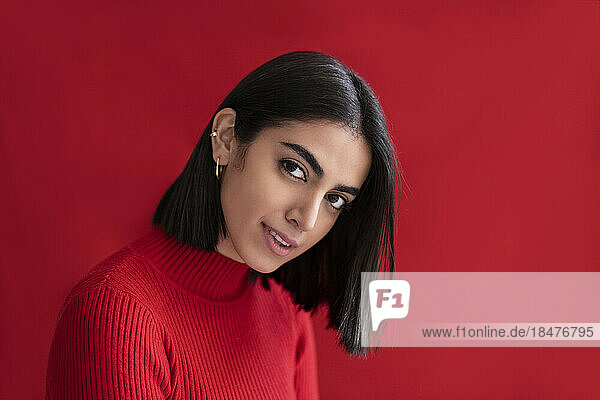 Smiling beautiful woman against red background