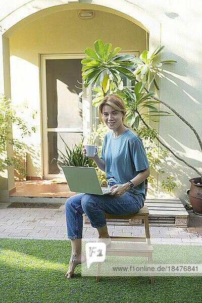 Freelancer with laptop sitting on bench
