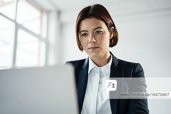 Businesswoman working on laptop at workplace