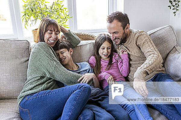 Happy man and woman spending time with children at home