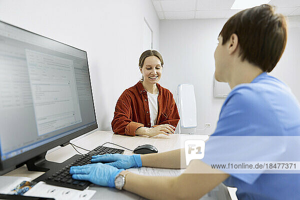 Lächelnder Patient diskutiert mit Augenarzt in der Klinik