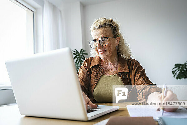 Lächelnde Geschäftsfrau mit Vitiligo-Haut  die im Heimbüro arbeitet