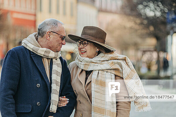 Älteres Paar trägt Schals und redet miteinander