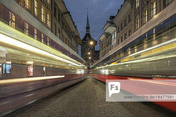 Switzerland  Bern Canton  Bern  Blurred motion of cable cars passing street at dusk