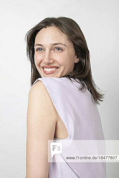 Cheerful young woman by white background