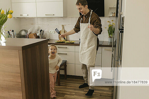 Father and daughter having fun in kitchen at home