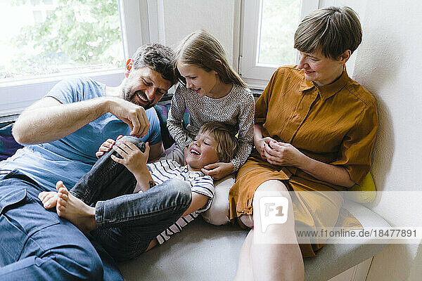 Verspielte Familie genießt es  zu Hause zu sitzen