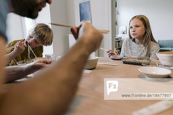 Family eating lunch together on dining table at home