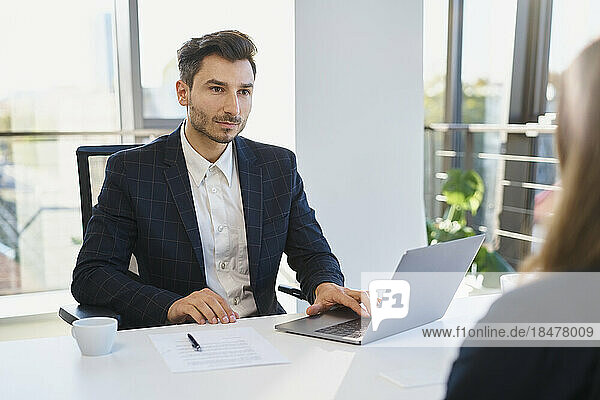 Recruiter with laptop looking at candidate in interview