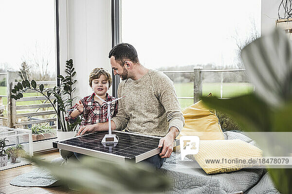 Son talking to father about wind turbine at home