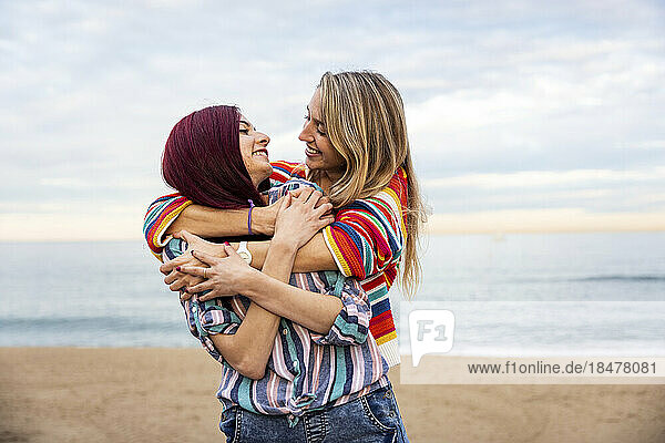 Woman hugging friend from behind at beach