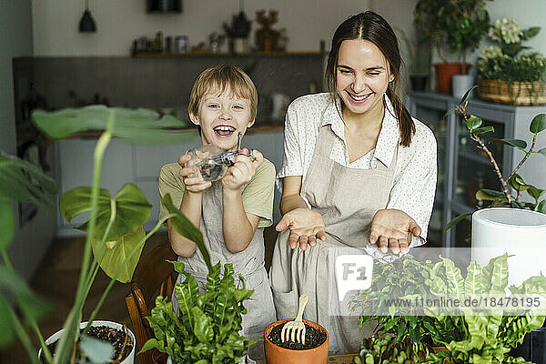 Happy mother and son taking care of plants at home