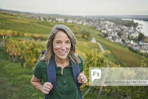 Happy woman with backpack on hill