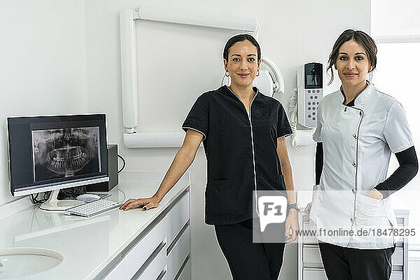 Female doctors standing together by desk at clinic